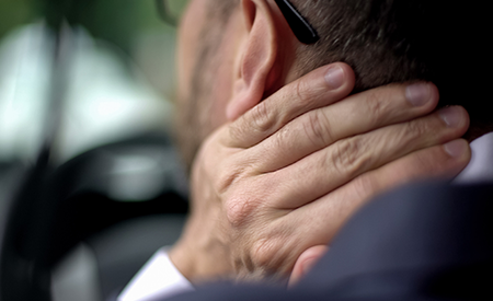 Man rubbing his neck after whiplash injury during a rear-end accident