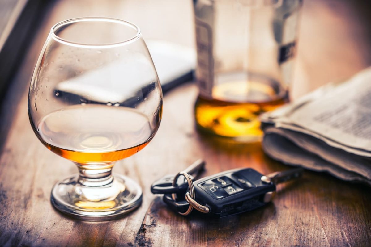 Car keys next to a bottle and snifter of brandy, potentially causing a situation where punitive damages would be awarded